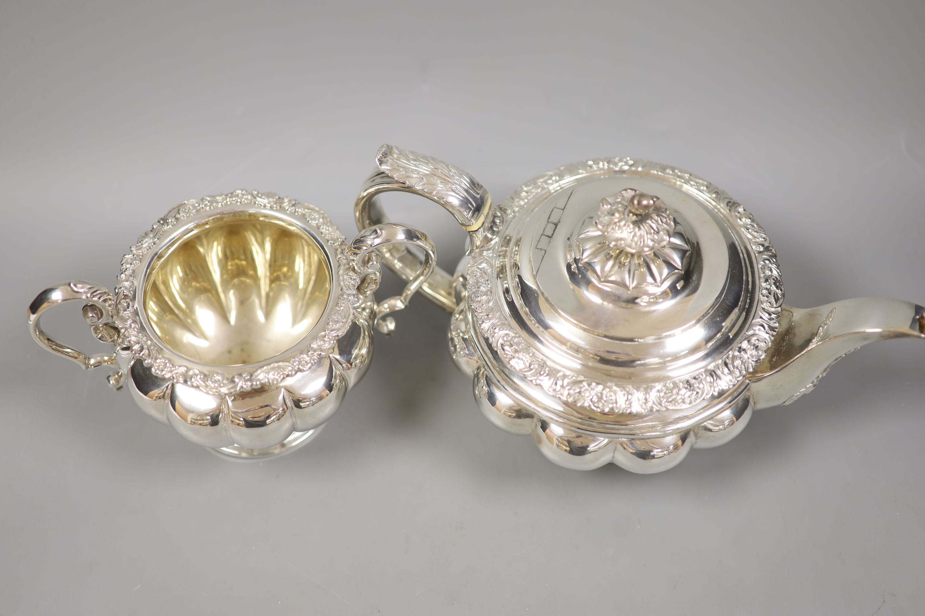 A large Georgian silver teapot, marks rubbed, with an associated twin handled sugar basin, Sheffield, 1864 by Henry Wilkinson & Co
